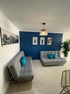 - un salon avec deux canapés et un mur bleu dans l'établissement Cabrero Beach 1212, à Carthagène des Indes
