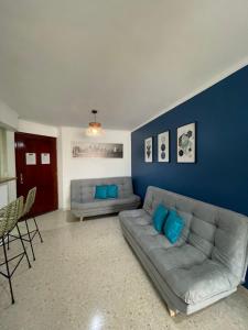 - un salon avec un canapé et un mur bleu dans l'établissement Cabrero Beach 1212, à Carthagène des Indes