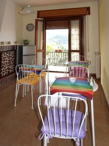 cocina con mesa y sillas y balcón en B&B L'Armonia, en Fabriano