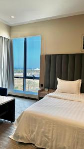 a bedroom with a large bed and a large window at شقق الريم الجديد للشقق المخدومة Al Reem Al Jadid residence in Yanbu