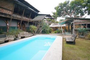 una gran piscina frente a una casa en La Fauna Hotel, en Puerto Maldonado