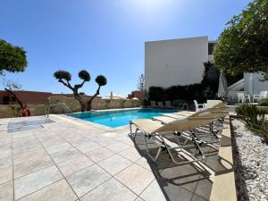 a pool with chairs and a table and a swimming pool at Villa Aliki Piskopiano in Hersonissos