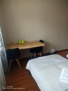 a bedroom with a desk with two chairs and a bed at tsogoo's geust house in Ulaanbaatar
