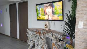 TV de pantalla plana en la pared con mesa en Apartamentos Commodore Bay Club, en San Andrés