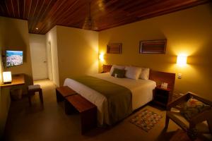 a bedroom with a large bed and a tv at Hotel El Abuelo in Carhuaz