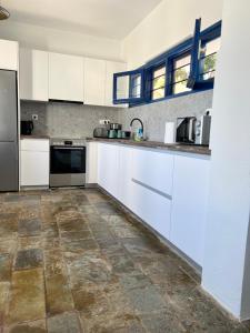 a kitchen with white cabinets and a tile floor at Villa Aliki Piskopiano in Hersonissos
