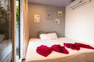 una camera da letto con un letto con fiocchi rossi sopra di Casa para 4 personas con A/C a 200 mts de la playa Low Tide - Popoyo Aparts a Tola