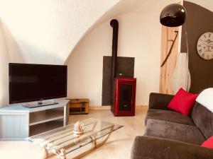 uma sala de estar com um sofá e uma televisão de ecrã plano em Gîtes de Chauvet em Gap