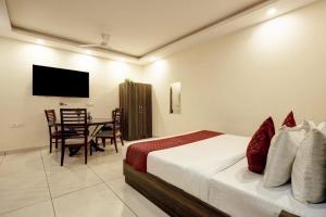 a bedroom with a bed and a table and a television at Hotel New City Lite in New Delhi