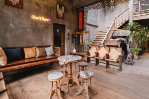 a room with a bench and stools and a staircase at House Of Passion Amphawa in Amphawa