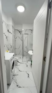 a white bathroom with a toilet and a sink at The beach nest in Shëngjin