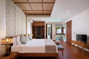 a bedroom with a large bed and a television at Beautiful Bali Villas in Legian