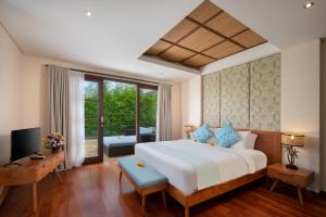 a bedroom with a large white bed and a television at Beautiful Bali Villas - 6 mins walk to the beach in Legian +22 photos