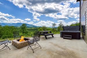 eine Terrasse mit einer Feuerstelle, einer Couch und einem Tisch in der Unterkunft Grand Vista View- Breathtaking Views, FREE tickets for each paid day, Hot Tub, WIFI in Sevierville