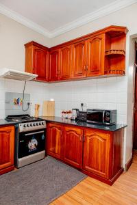 cocina con armarios de madera y fogones en Baraa House Arusha, en Arusha 8 fotos más