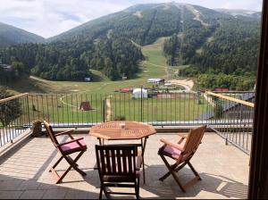 a table and chairs on a balcony with a view of a mountain at Studio&apartments Snow in Bjelašnica