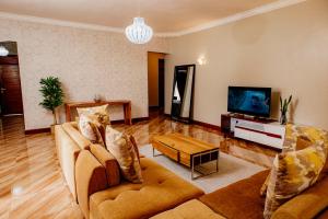 アルーシャにあるBaraa House Arushaのソファ2つとテレビのあるリビングルーム
