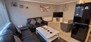 a living room with a couch and a table at Large Brick Chalet sleeps 6 mins to beach and amusements in Leysdown-on-Sea