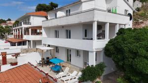 widok z lotu ptaka na biały budynek z krzesłami i stołami w obiekcie Apartments Peronja Jelsa Seafront w mieście Jelsa
