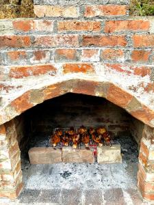 a brick oven with chickens cooking in it at Wayside Cottage in Batumi