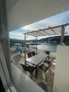 d'une table et de chaises sur un balcon avec vue sur l'eau. dans l'établissement Apartments Peronja Jelsa Seafront, à Jelsa