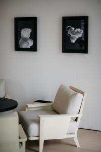 ein Wohnzimmer mit Sofa und zwei Bildern an der Wand in der Unterkunft The Singapore EDITION in Singapur
