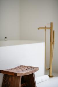 a wooden table in a bathroom with a shower at The Singapore EDITION in Singapore