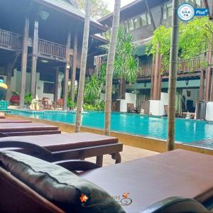 una piscina en un edificio con mesas y sillas en Yantarasri Resort, en Chiang Mai