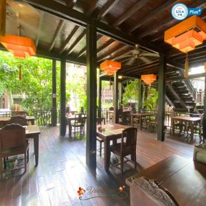 un restaurante con mesas de madera, sillas y luces en Yantarasri Resort, en Chiang Mai