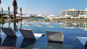una piscina d'acqua con sedie in un resort di Cloud 7 Residences Ayla Aqaba ad Aqaba