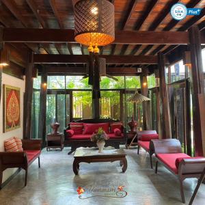 sala de estar con sofá rojo y sillas en Yantarasri Resort, en Chiang Mai