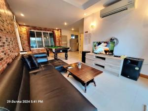 een woonkamer met een bank en een tafeltennistafel bij Plus2 Hua-Hin Private Poolvilla from beach 3km in Hua Hin