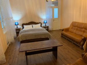 a bedroom with a bed and a couch at Villa Bodbe in Sighnaghi