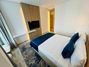 STEAUA DE MARE - Olimp Resort في أوليمب: غرفة نوم بسرير ومخدات زرقاء وتلفزيون