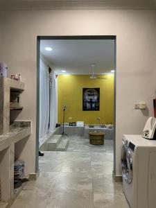 a laundry room with a washing machine and a yellow wall at Peponi Lodge in Jambiani
