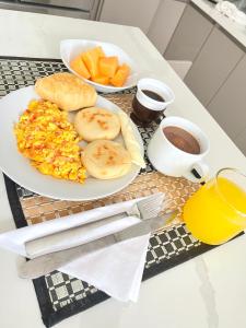 a breakfast table with a plate of food and a cup of coffee at Hotel Olam Deluxe Valledupar in Valledupar