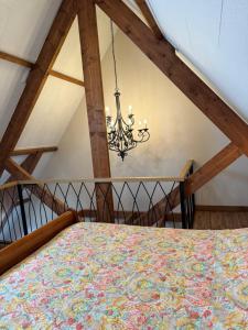 1 dormitorio con 1 cama con lámpara de araña en Vino Grando 't Klooster en Odiliapeel