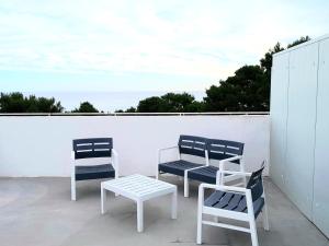 three chairs and a coffee table on a patio at ML Apartments in Vieste