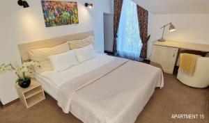 Un dormitorio con una cama grande con una colcha blanca. en HOME Apart-Hotel Vilnius, en Vilna