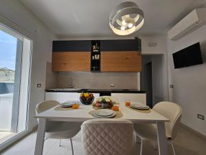 a white table and chairs in a kitchen with a table and a window at Grey House 4 100mt dal mare in Tortoreto Lido