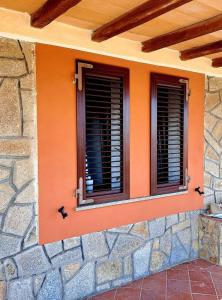 two windows on the side of a building at Gelsi Holiday Home La Maddalena in La Maddalena