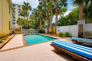 a swimming pool with a bench next to a building at Be A Nomad - Pool - 1bdr Just 1 Block to the Beach in Jacksonville Beach