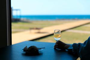 einen Tisch mit einem Teller Essen und einem Glas Wasser in der Unterkunft Oruga Resort -Trailer Cottage & Cafe - in Sakai