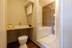 y baño con aseo, lavabo y ducha. en Oruga Resort -Trailer Cottage & Cafe -, en Sakai