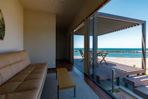 阪井市的住宿－Oruga Resort -Trailer Cottage & Cafe -，带沙发的客厅,享有海滩美景