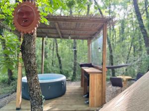a wooden pergola with a bath tub next to a tree at APACHE in Loubès-Bernac +15 photos