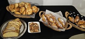 a table topped with baskets of bread and pastries at Penzion Fiesta in Prostějov