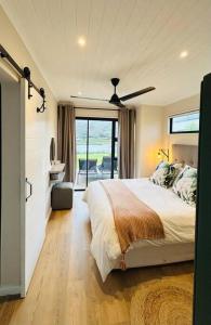 a bedroom with a large bed and a balcony at The Old Oke Riverhouse in Malgas