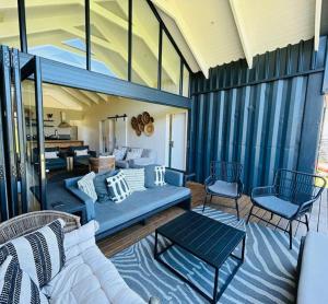 a living room with a couch and chairs on a porch at The Old Oke Riverhouse in Malgas