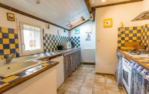 una cucina con pareti piastrellate blu e gialle e un lavandino di Gîte Enzo a Cabanès